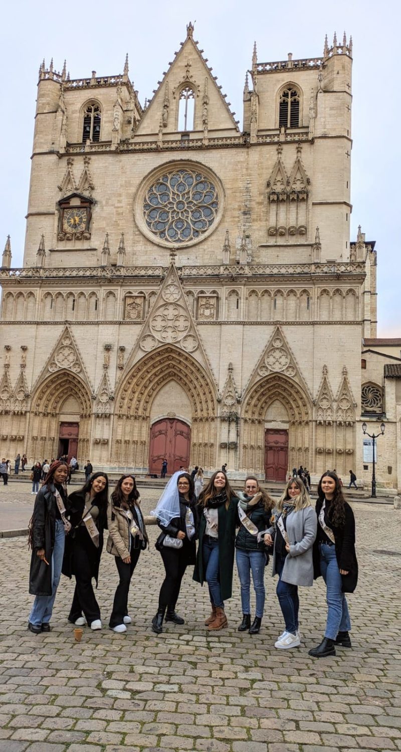 Photo d'un groupe pour un EVJF faisant un escape game au Vieux Lyon devant la cathédrale Saint Jean